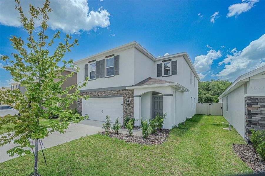 Front exterior of a new home in Deerbrook, Land O' Lakes, FL, highlighting curb appeal (Image 2).