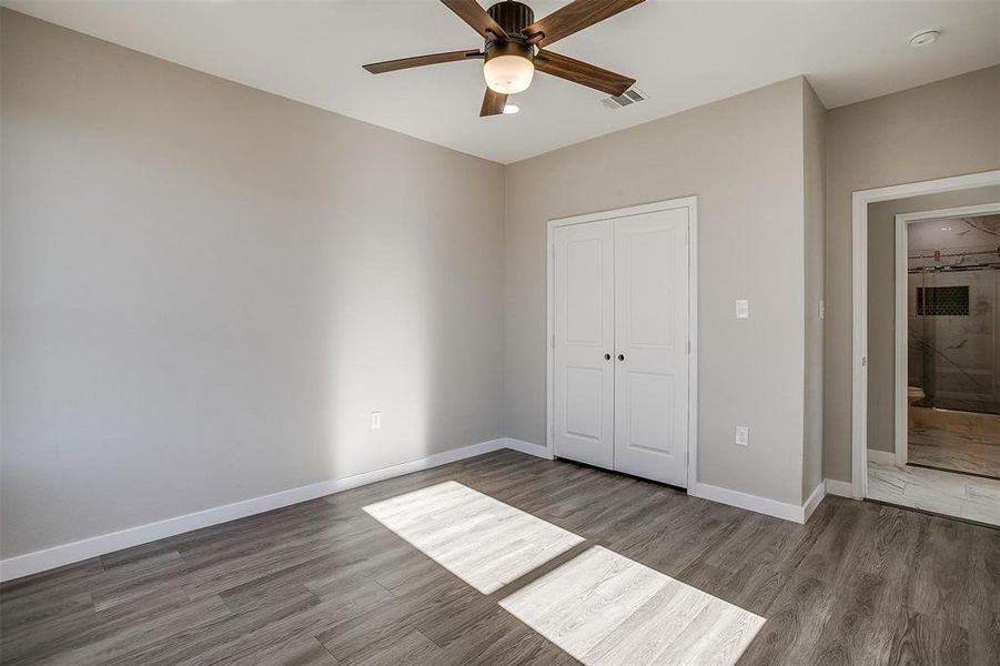 Unfurnished bedroom with ceiling fan, a closet, and hardwood / wood-style floors