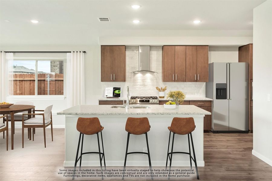 Kitchen with large island, three bar stools, wood cabinets, stainless steel appliances, and white tile backsplash