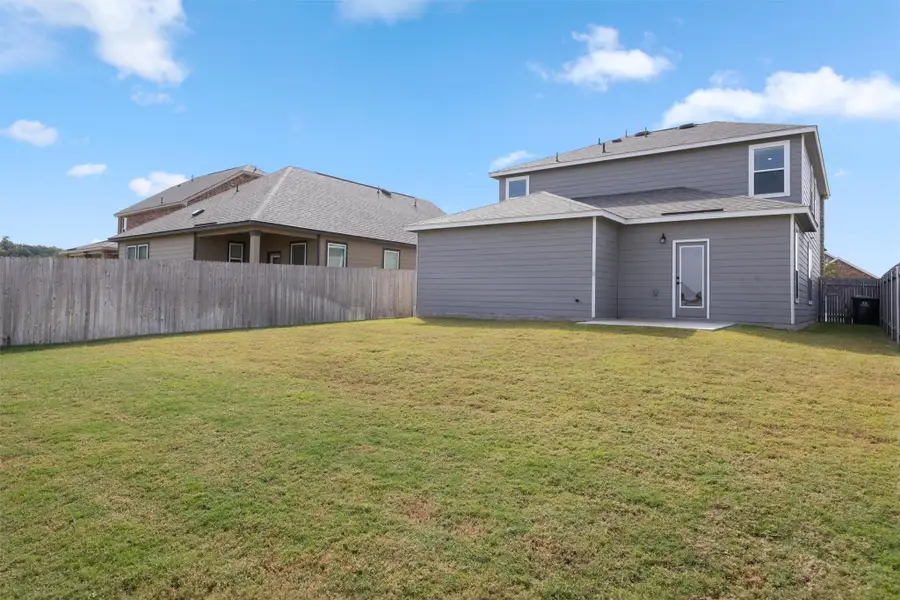 Rear view of property with a fenced backyard, a patio area, and a shingled roof