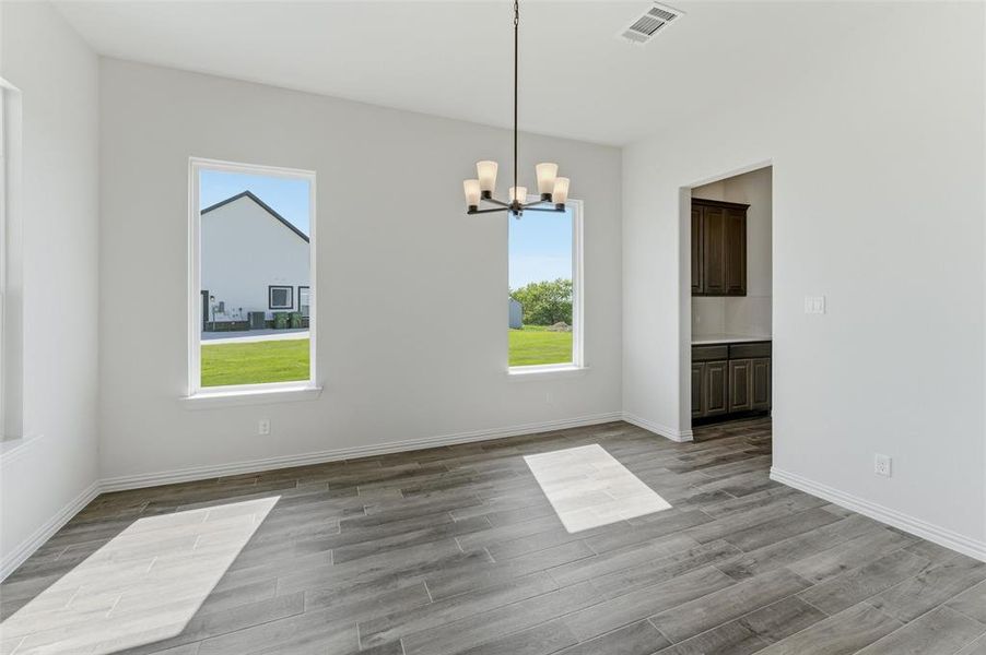 Unfurnished dining area featuring suspended lighting and light wood-style flooring Unfurnished dining area featuring suspended lighting and light wood-style flooring
