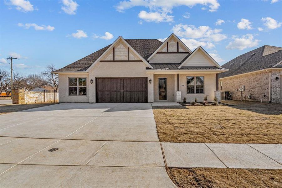 View of front of house featuring a garage and a front yard