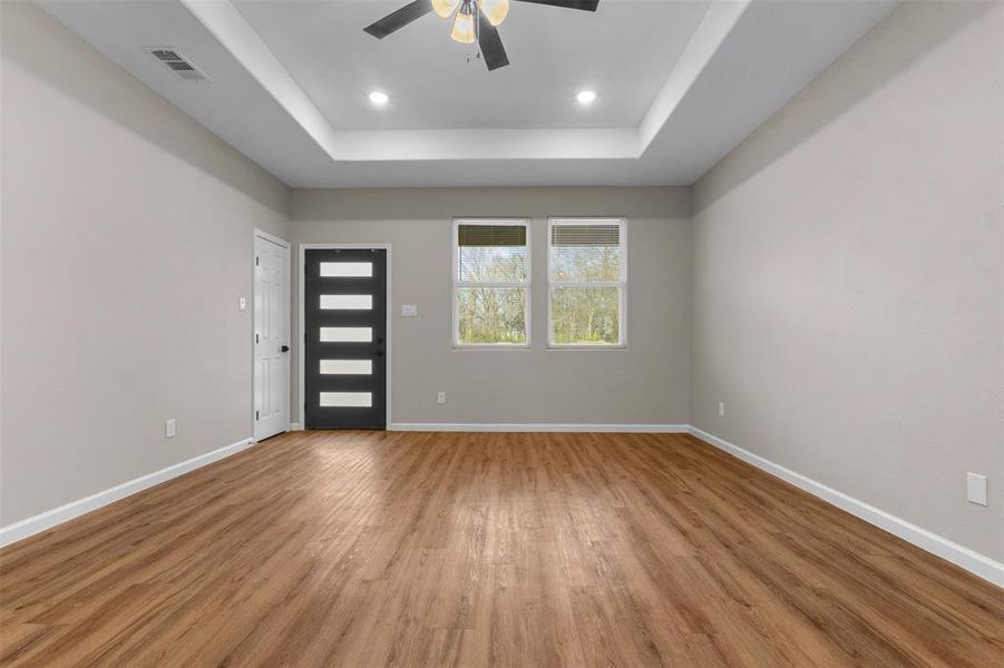 Entryway with wood finished floors, a raised ceiling, ceiling fan, and recessed lighting