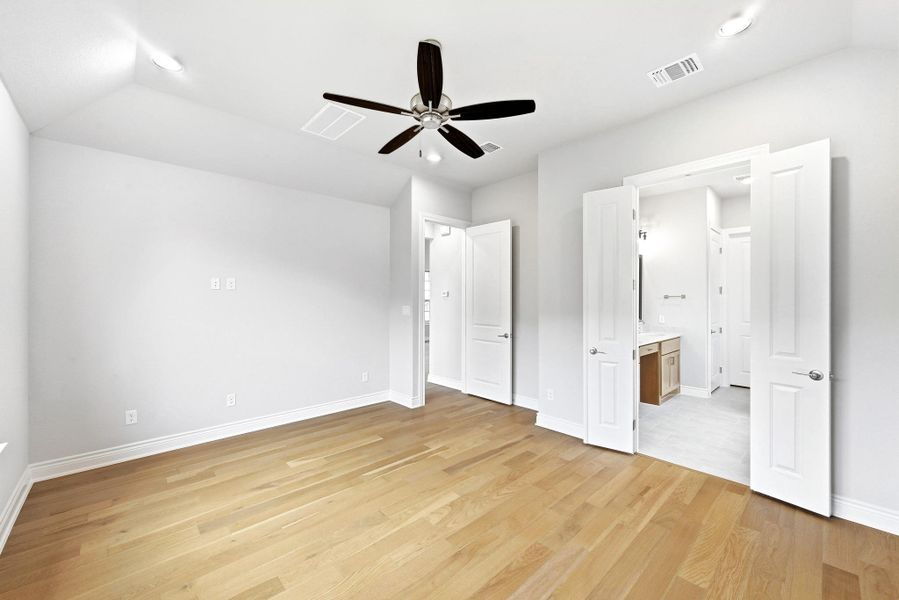 Spacious room featuring wood-finish flooring and a contemporary ceiling fan