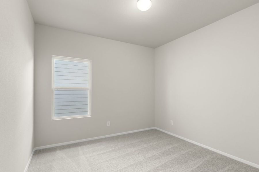 Image of a bedroom with light grey walls, tan carpeting, and a window with white trim Image of a bedroom with light grey walls, tan carpeting, and a window with white trim