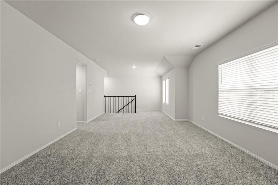 Unfurnished room with carpet floors and lofted ceiling