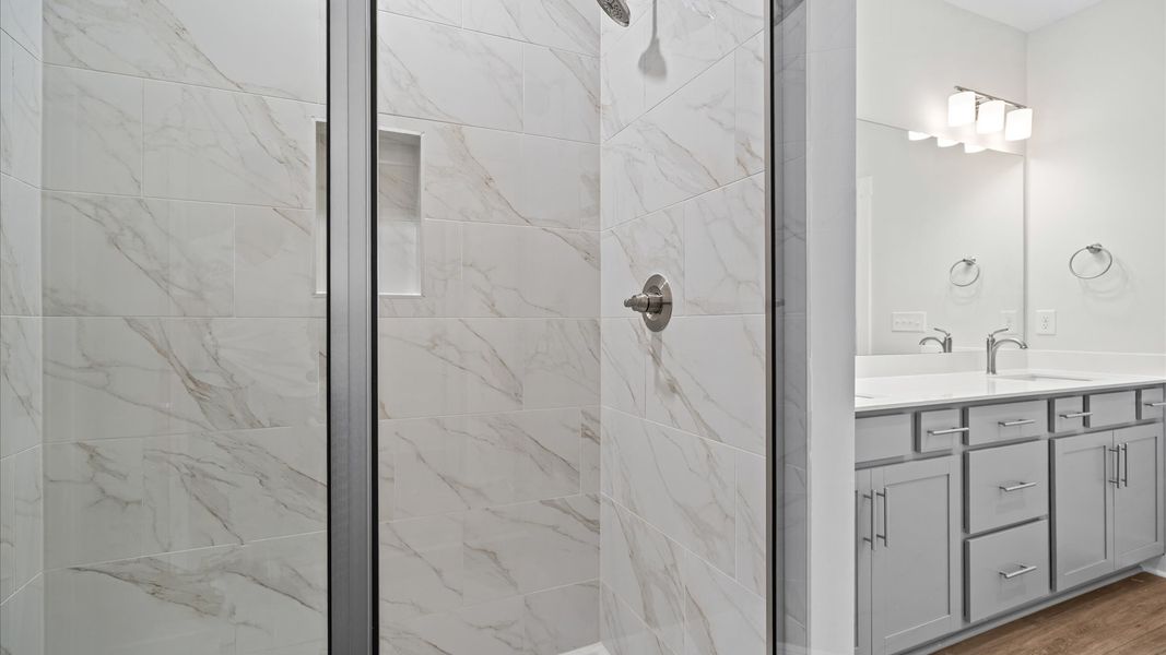 Exceptional en-suite with dual vanity and glass-enclosed tiled walk-in shower at Silo Ridge by DRB Homes in Anderson, SC