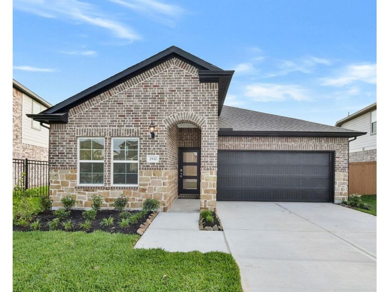Front exterior of a new home in Sunterra, Katy, TX, highlighting curb appeal (Image 1).