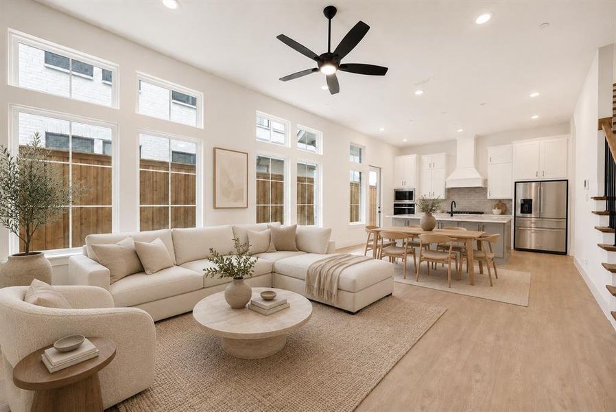 Open-concept living space featuring high ceilings, recessed lighting, and light wood-finish flooring