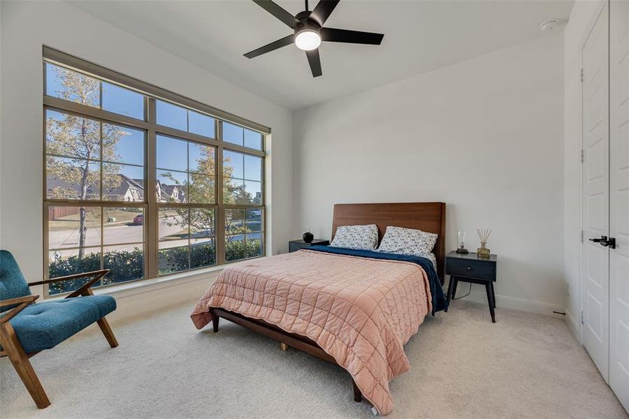 Bedroom with carpet, ceiling fan, and a residential view