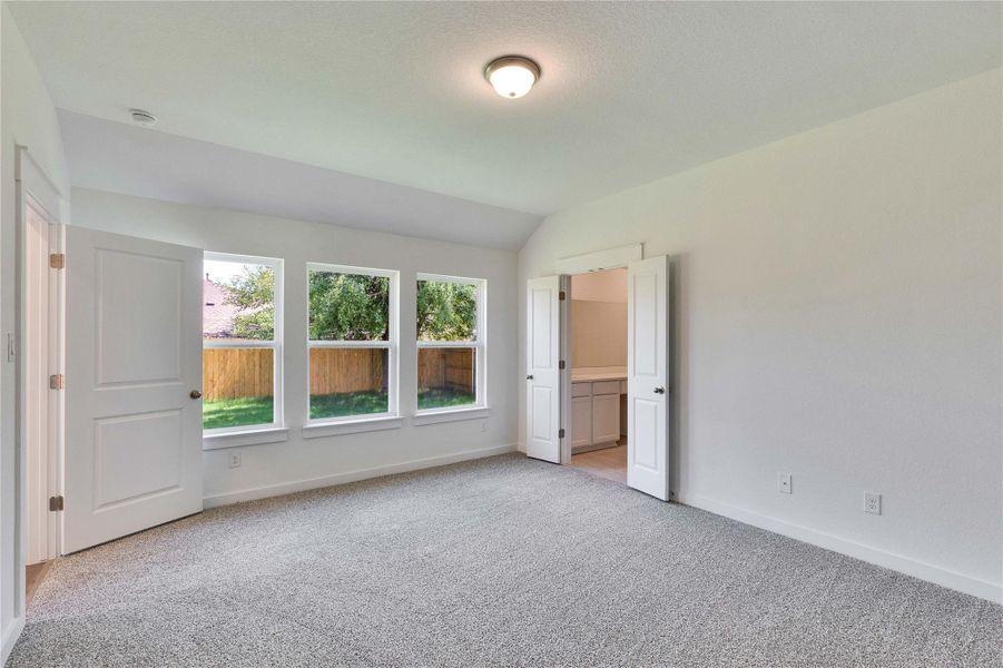 Carpeted room with a vaulted ceiling and three large windows