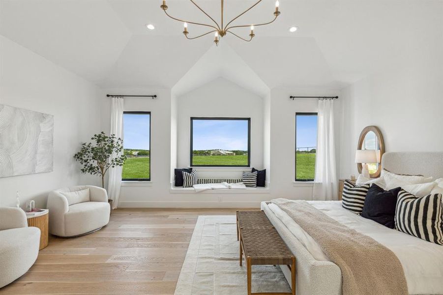 Primary bedroom featuring multiple windows, vaulted ceiling, and a chandelier