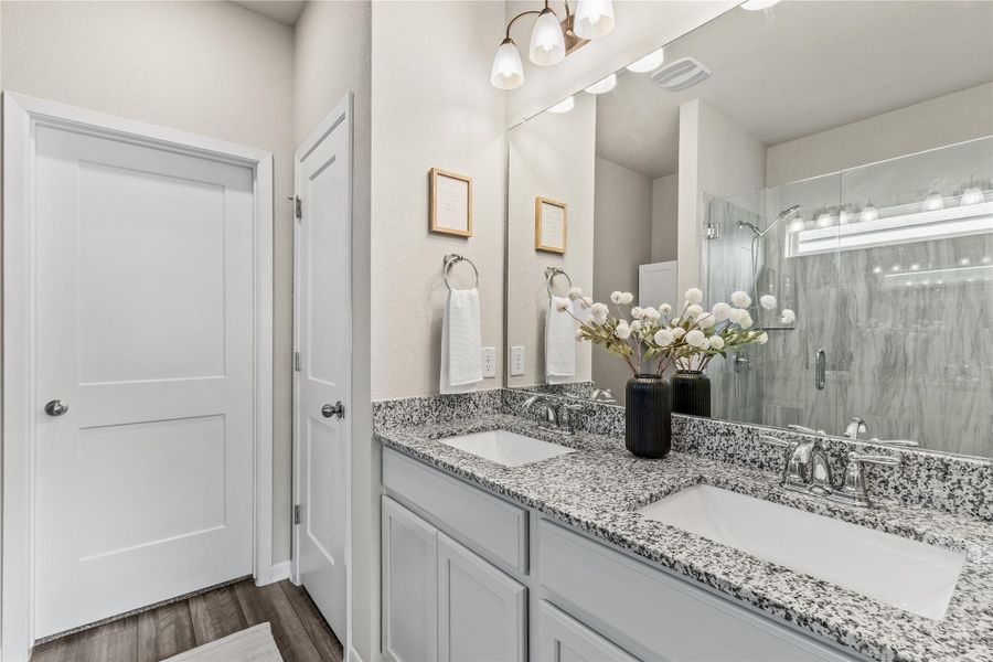 Double vanities with granite counters complement the contemporary shower in this well-appointed bathroom. Double vanities with granite counters complement the contemporary shower in this well-appointed bathroom.