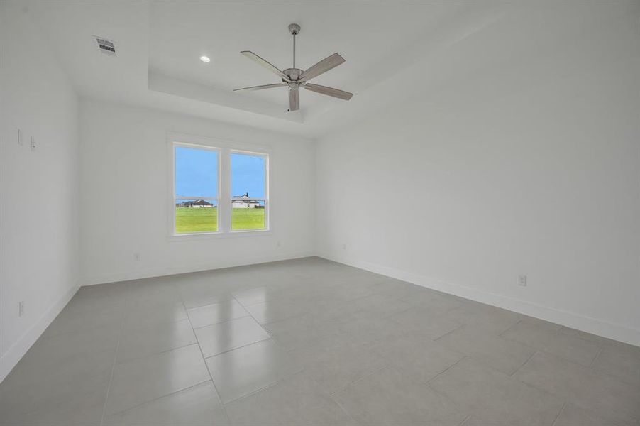 Master bathroom featuring ceiling fan, visible vents, baseboards, and a raised ceiling Master bathroom featuring ceiling fan, visible vents, baseboards, and a raised ceiling