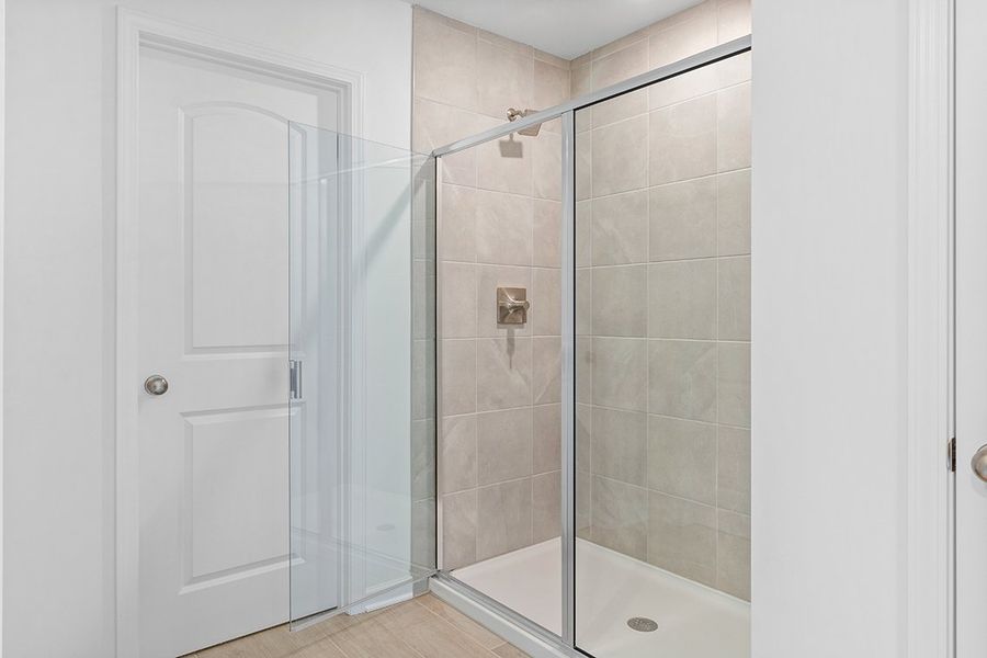 A bathroom with a shower unit and a bathtub. A bathroom with a shower unit and a bathtub.