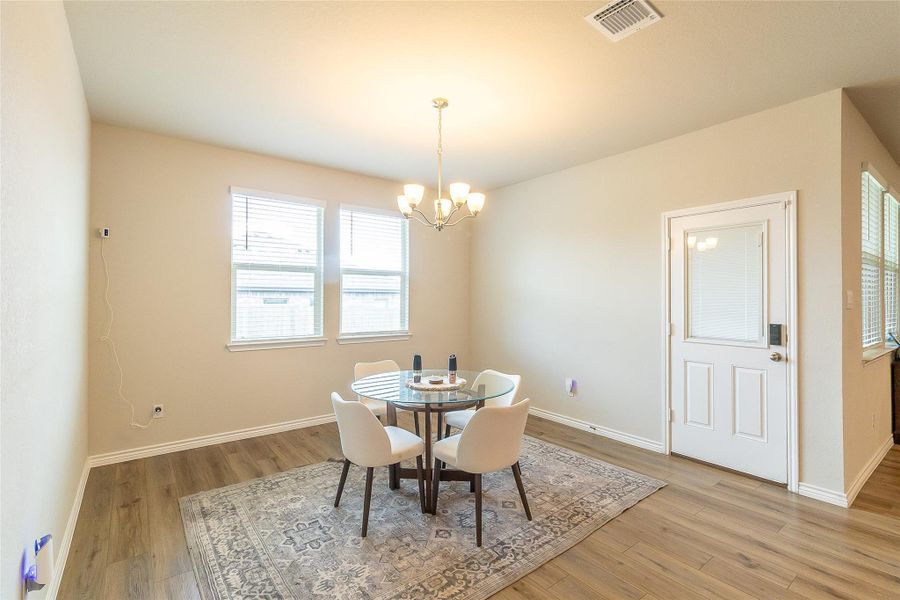 Natural light floods this inviting dining space, featuring a classic chandelier and durable hardwood flooring. Natural light floods this inviting dining space, featuring a classic chandelier and durable hardwood flooring.