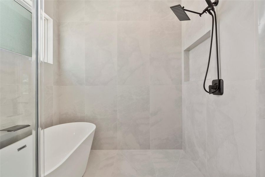 Spa-inspired walk-in shower with floor-to-ceiling tile, and an elegant freestanding soaking tub Spa-inspired walk-in shower with floor-to-ceiling tile, and an elegant freestanding soaking tub