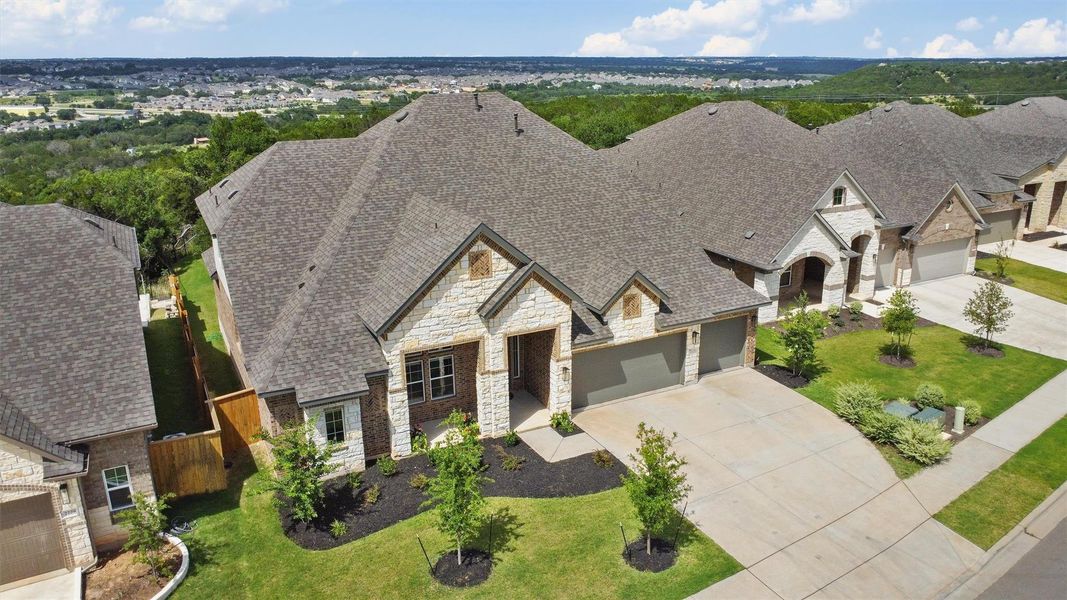 View of front facade featuring stone siding, concrete driveway, a shingled roof, and an attached garage View of front facade featuring stone siding, concrete driveway, a shingled roof, and an attached garage