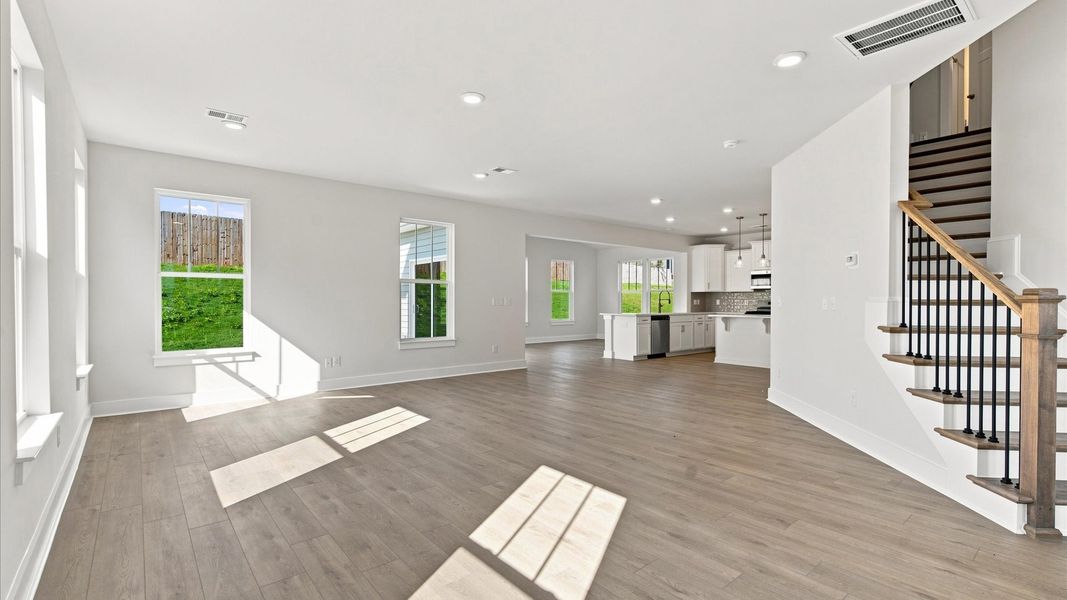 Spacious family room with rich hardwood flooring and elegant trim work in a reputable DRB Homes build