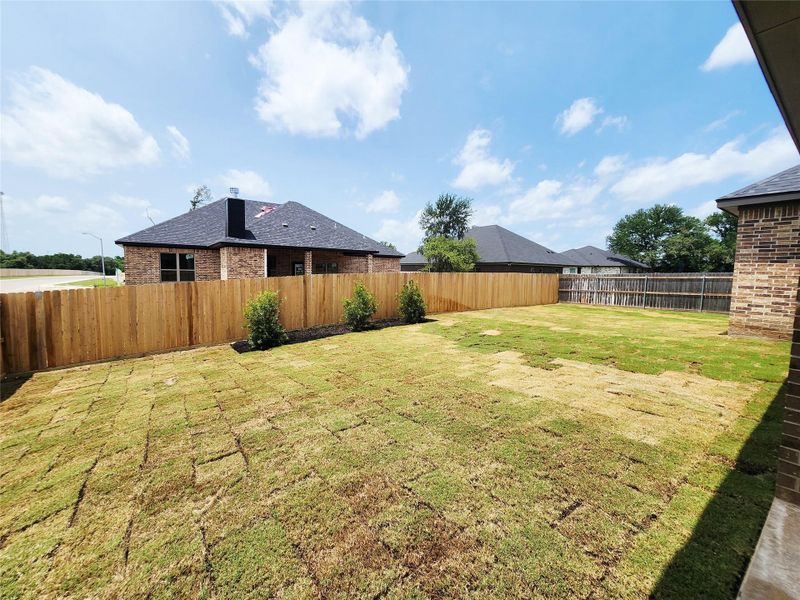 A spacious backyard with newly laid sod and a privacy fence provides a perfect outdoor sanctuary. A spacious backyard with newly laid sod and a privacy fence provides a perfect outdoor sanctuary.