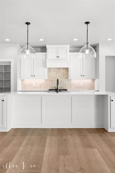 Kitchen featuring backsplash, pendant lighting, white cabinetry, light wood finished floors, and recessed lighting