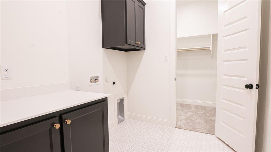 Laundry area featuring cabinet space, washer hookup, and electric dryer hookup Laundry area featuring cabinet space, washer hookup, and electric dryer hookup