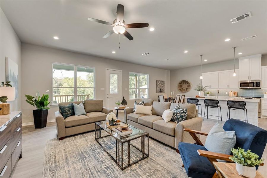 Living room featuring ceiling fan, a healthy amount of sunlight, and light wood-type flooring