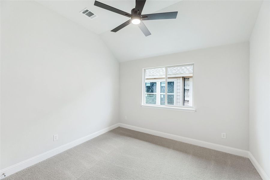 Empty bedroom with vaulted ceiling, ceiling fan, carpet flooring, and single window