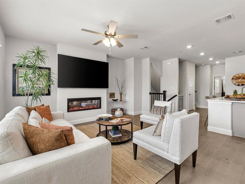 A closer look at the living room setup emphasizes the upscale modern fireplace centerpiece, recessed lighting, and sweeping neighborhood views.