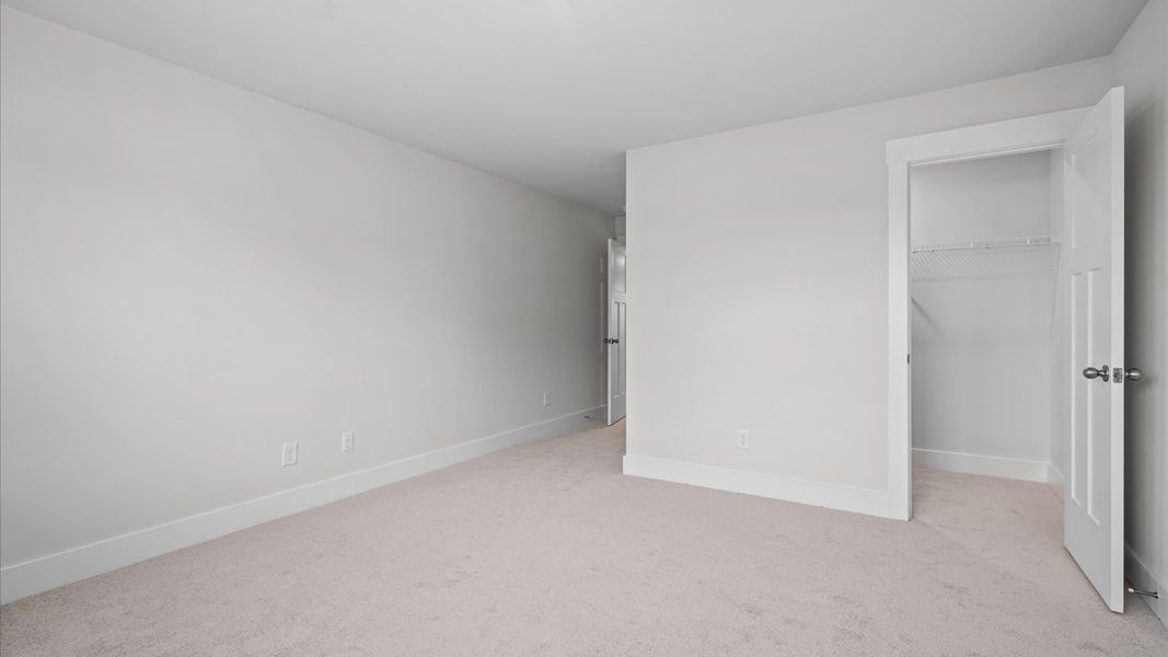 Elegant bedroom retreat featuring soft carpeting and a thoughtfully designed walk-in closet at Silo Ridge in Anderson, SC