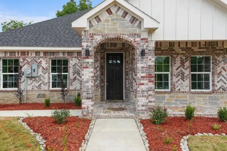 Brick and stone façade with herringbone pattern accents Brick and stone façade with herringbone pattern accents