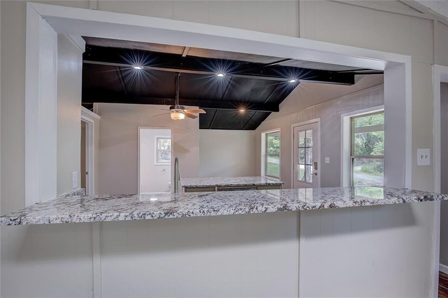 Kitchen featuring ceiling fan and beam ceiling