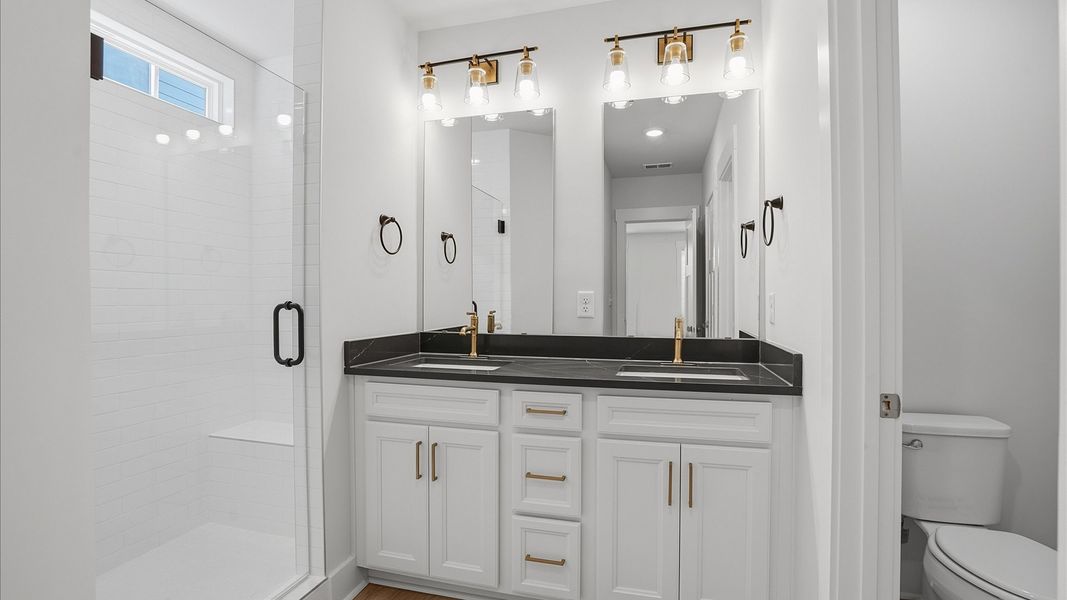 Highly functional and elegant en-suite with dual vanities, tiled walk-in shower, and refined finishes at Pelham Crossing