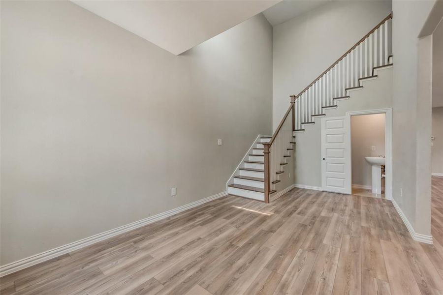 Stairs with a towering ceiling and light hardwood / wood-style flooring