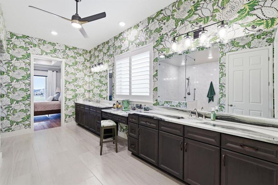 Spa-Inspired Primary En-Suite Bath with Coordinating Designer Thibaut Wallpaper, Coordinating Portinari Dolomite Countertops, Spacious Curb-less Shower, Private Water Closet, and an Oversized Walk-in Closet.
