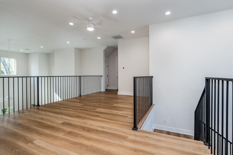 Upstairs landing with sleek black railings and a bright open flow. Upstairs landing with sleek black railings and a bright open flow.