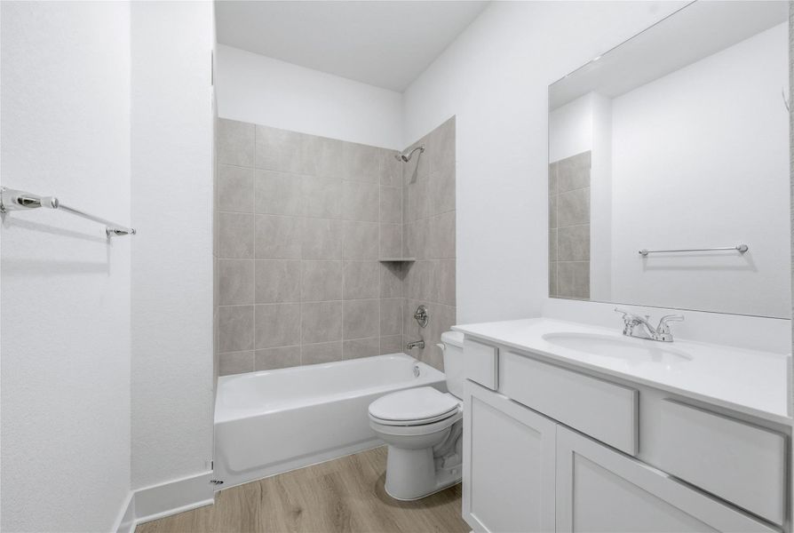Bathroom with shower / tub combination, vanity, and light wood finished floors