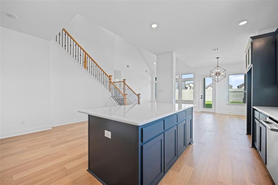 Kitchen featuring a kitchen island, light hardwood / wood-style flooring, pendant lighting, and a chandelier