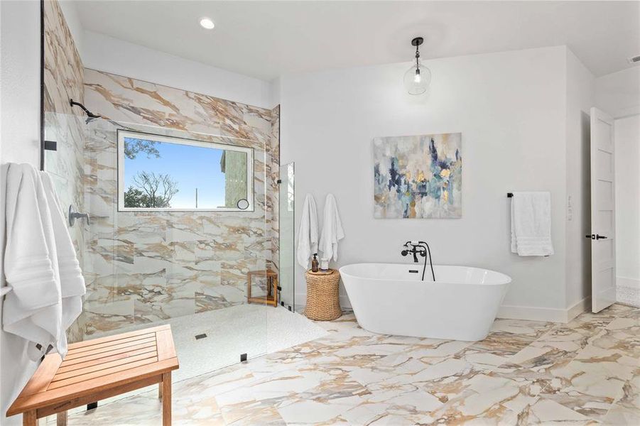 Bathroom featuring a marble finish shower, a soaking tub, and marble tiled floors
