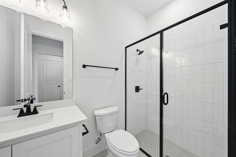 Bathroom with a stall shower, vanity, and a textured wall