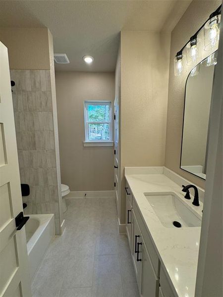 Bathroom featuring vanity, shower / bathtub combination, and light tile patterned flooring Bathroom featuring vanity, shower / bathtub combination, and light tile patterned flooring