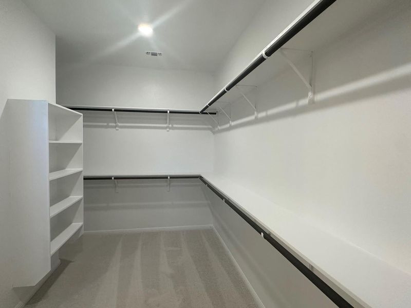 Walk in closet featuring light carpet Walk in closet featuring light carpet