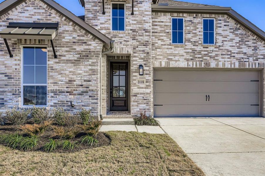 View of front facade featuring driveway and a garage