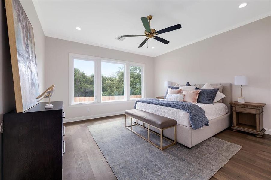 Bedroom featuring dark wood-style flooring, crown molding, recessed lighting, and a ceiling fan Bedroom featuring dark wood-style flooring, crown molding, recessed lighting, and a ceiling fan