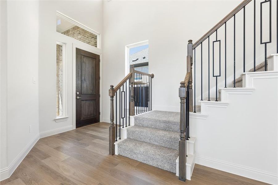 Foyer with light wood-type flooring and a high ceiling