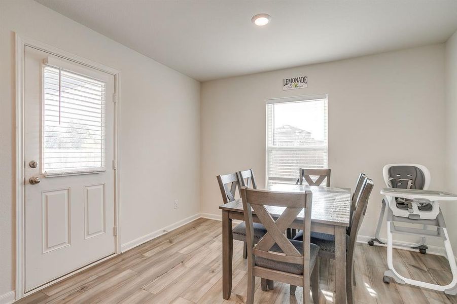 Dining area featuring light wood-style floors, plenty of natural light, and recessed lighting