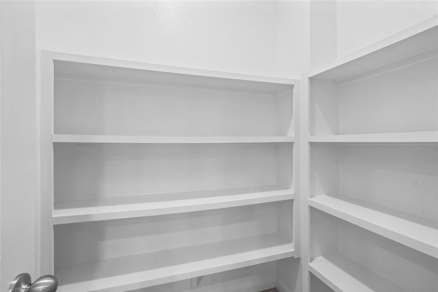The walk in pantry is well equipped with wooden shelving, keeping every jar and ingredient organized and within easy reach.