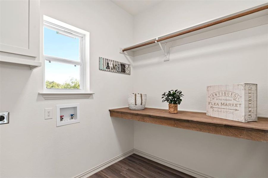 Really big laundry room with hanging space, a folding counter and cabinet!