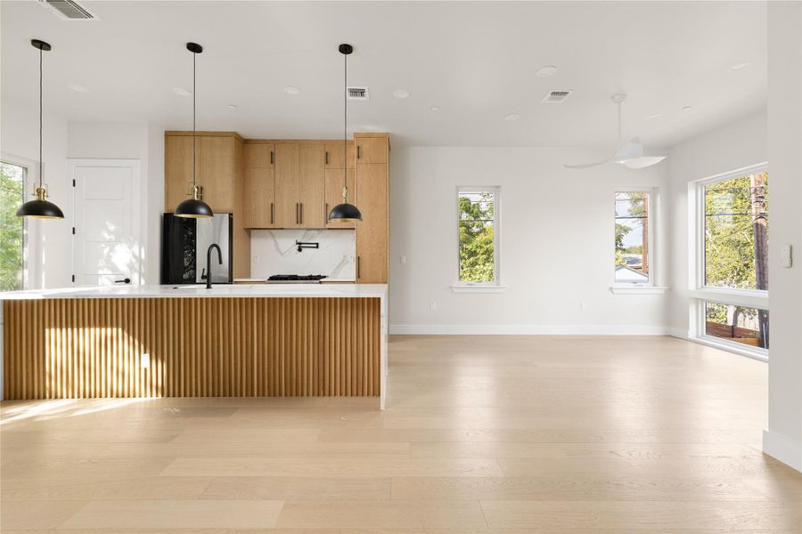 Gleaming hardwood floors and a ribbed wooden island define this light-filled open-plan interior.