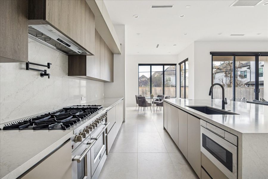 The kitchen has a gas range, pot filler, and built-in microwave and refrigerator.